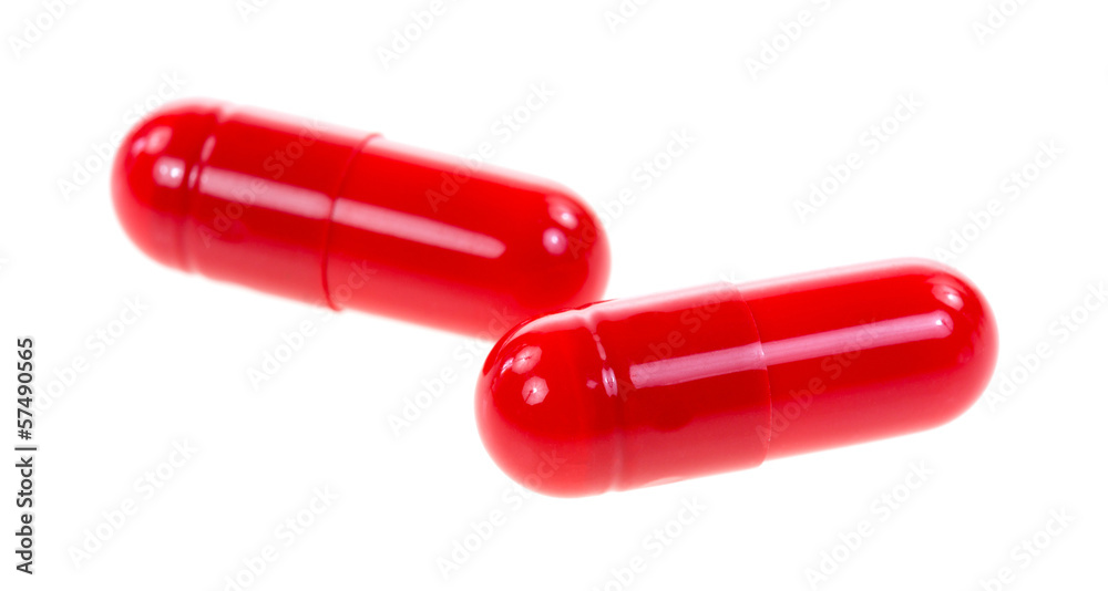 Red antibiotic capsules on a white background