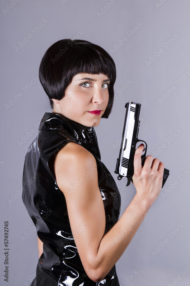 girl with dark shinny dress holding a gun. girl with dark shinny dress holding a gun.