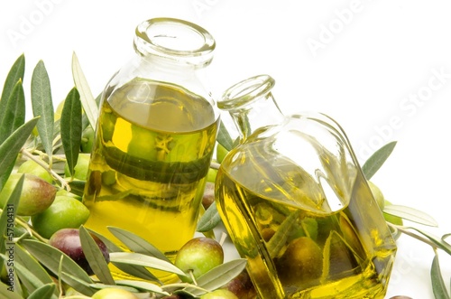 Aceite de oliva virgen rodeado de aceitunas recien cosechadas