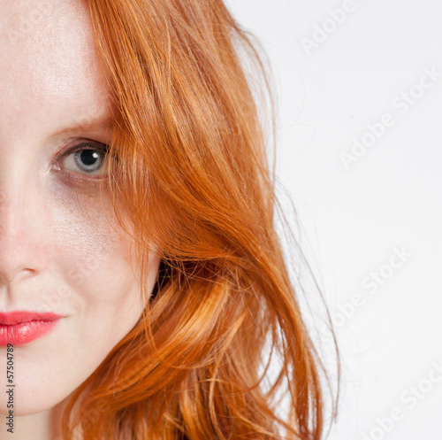 Half face portrait of a beautiful 20 year old redhead woman.
