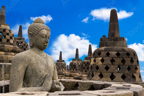 Buddha in Borobudur Temple against blue sky with clouds