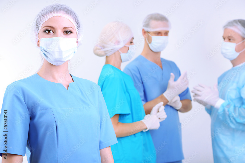 Surgeons standing on grey background Surgeons standing on grey background