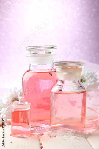 Glass bottles with color essence, on pink background