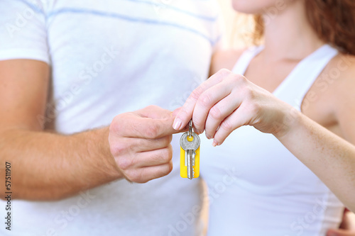 Young couple with keys to your new home close-up