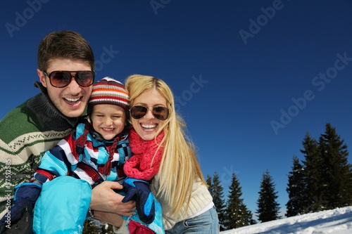 family having fun on fresh snow at winter
