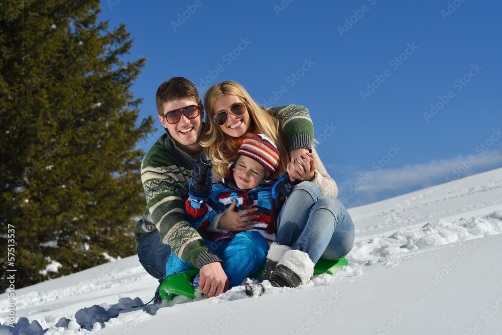 family having fun on fresh snow at winter