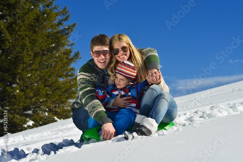 family having fun on fresh snow at winter