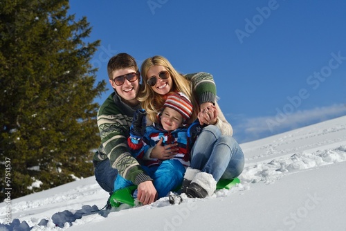 family having fun on fresh snow at winter