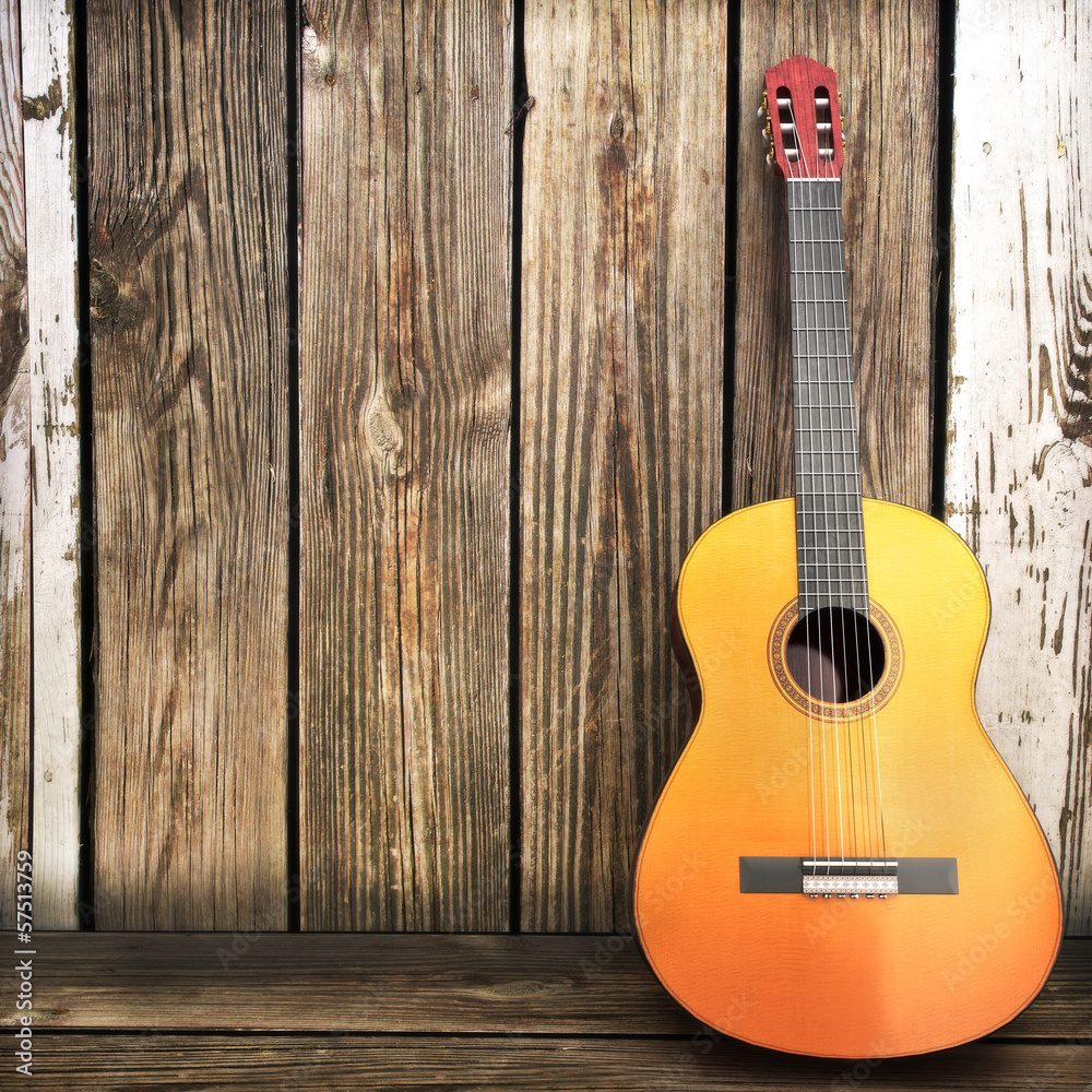 Fototapeta premium Acoustic wooden guitar leaning on a wooden fence.