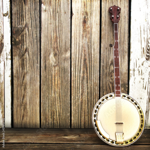 Banjo leaning on a wooden fence. Room for advertisment