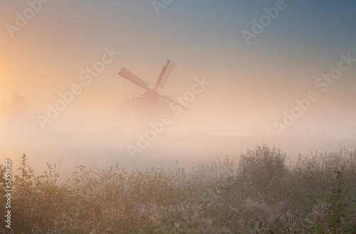 windmill silhouette in sunrise fog