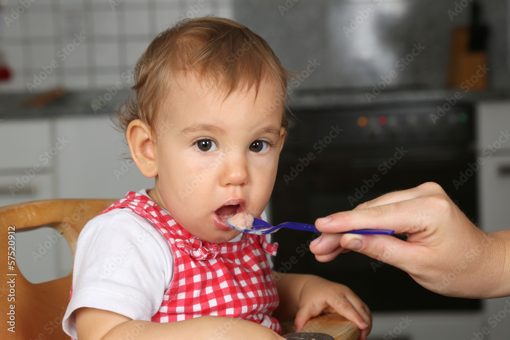 Baby öffnet Mund, Mutter füttert es mit Babybrei Baby öffnet Mund, Mutter füttert es mit Babybrei
