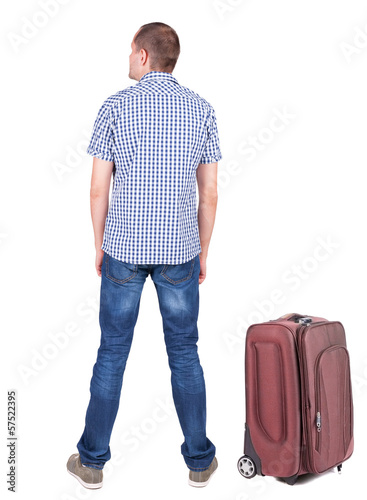 Back view of young man traveling with suitcas. © ghoststone