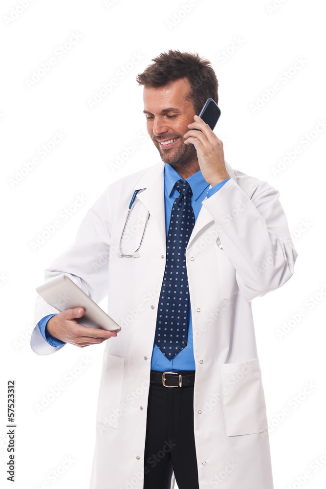 Doctor with mobile phone checking something on digital tablet Doctor with mobile phone checking something on digital tablet