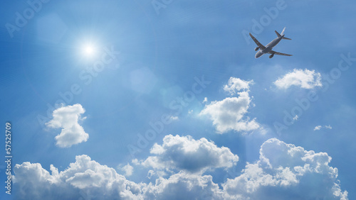 an airplane flying above blue clouds
