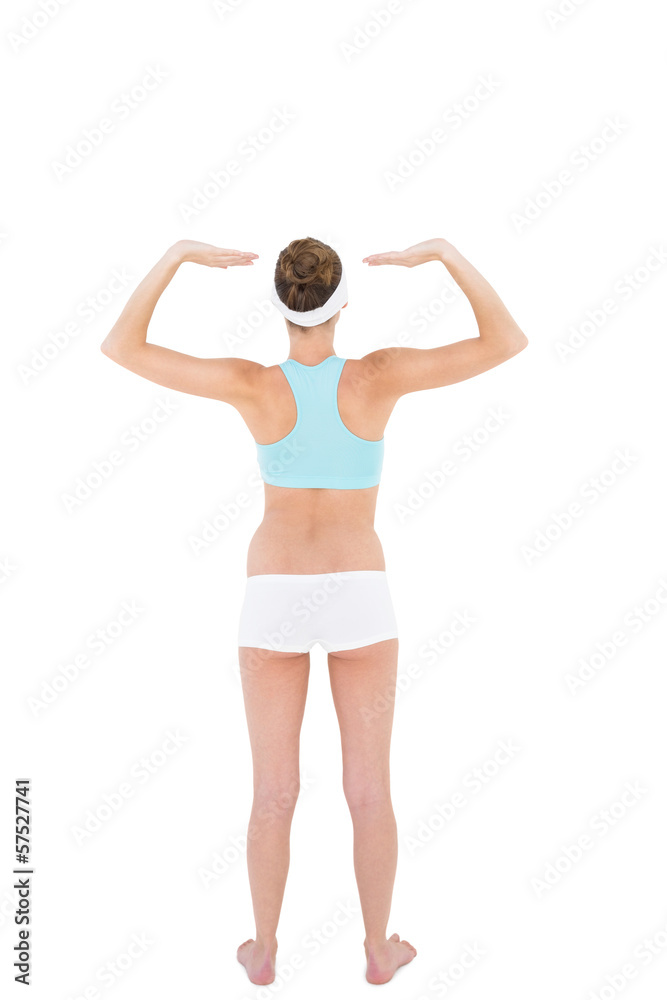 Rear view of slender woman wearing sportswear raising her arms Rear view of slender woman wearing sportswear raising her arms