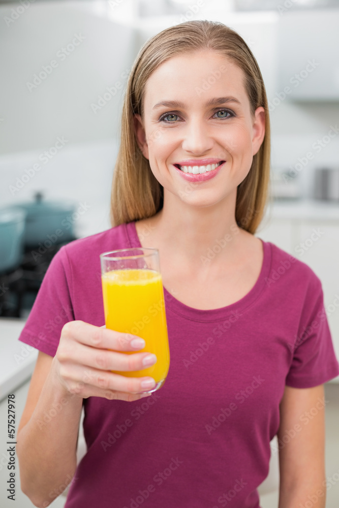Happy casual woman holding glass of orange juice Happy casual woman holding glass of orange juice