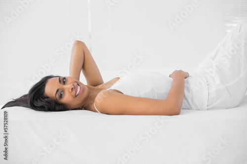 Lovely smiling woman posing lying on her bed