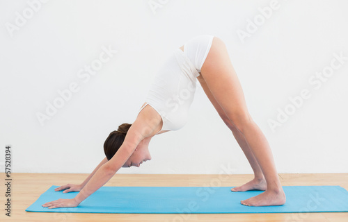 Side view of a woman exercising on mat