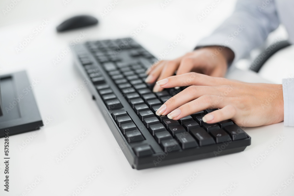 Hands typing on a keyboard in an office Hands typing on a keyboard in an office