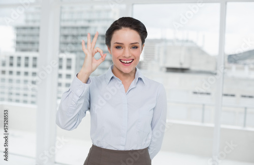 Elegant businesswoman gesturing ok sign in office