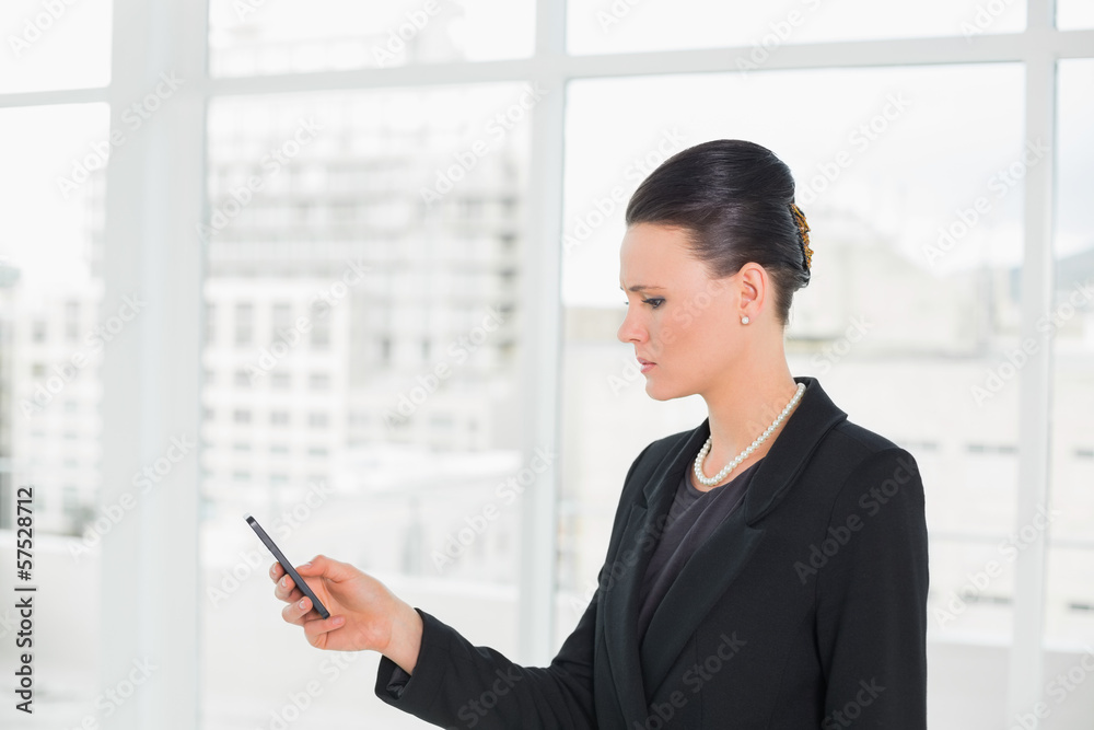 Elegant businesswoman looking at cellphone Elegant businesswoman looking at cellphone