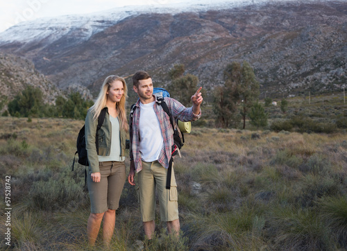 Fit young couple with backpacks on landscape