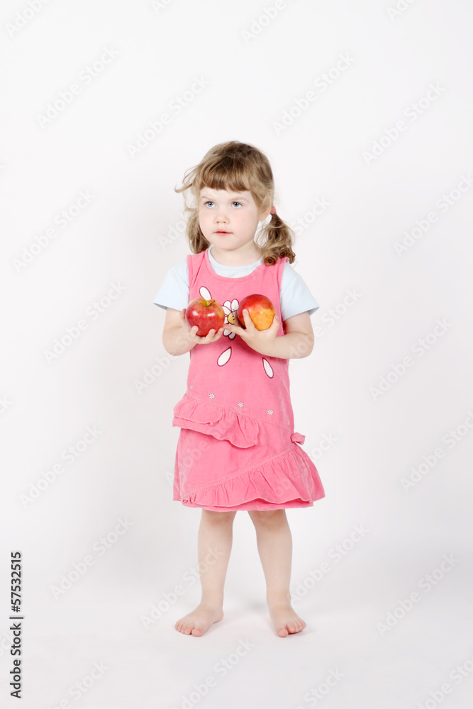 Little happy barefoot girl holds two red apples in hands on whit Little happy barefoot girl holds two red apples in hands on whit