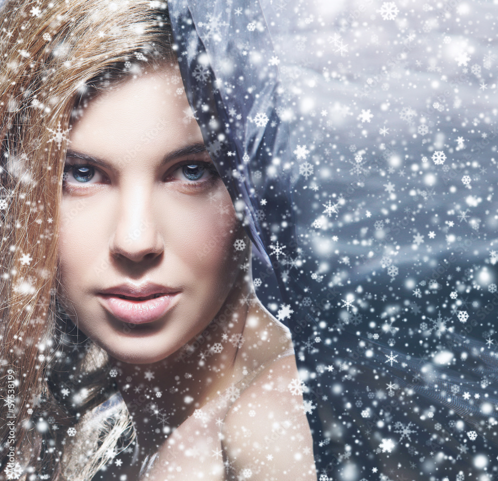 Beauty portrait of a young woman on a snowy background