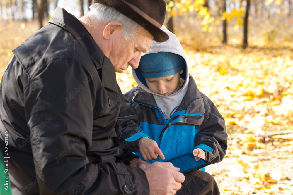 Grandfather and grandson sharing a tablet-pc Grandfather and grandson sharing a tablet-pc