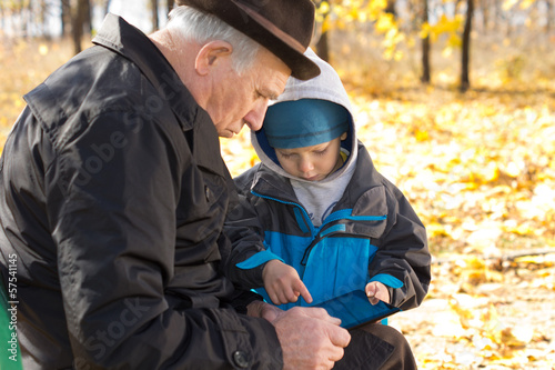 Grandfather and grandson sharing a tablet-pc