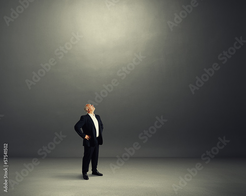 senior man standing in dark room