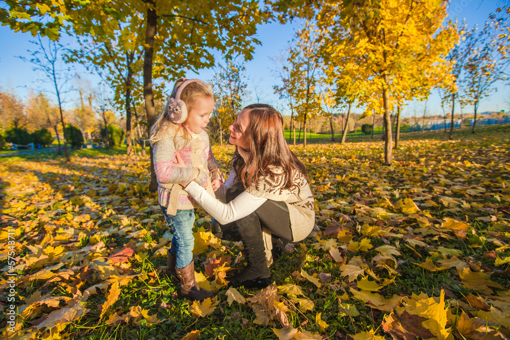 Little adorable girl and young mother in autumn park on sunny Little adorable girl and young mother in autumn park on sunny
