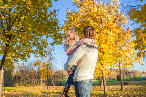 Back view of Little girl with happy father having fun in autumn © travnikovstudio