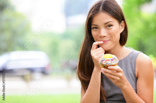 Schilderij op canvas Cupcake - woman eating cupcakes in New York