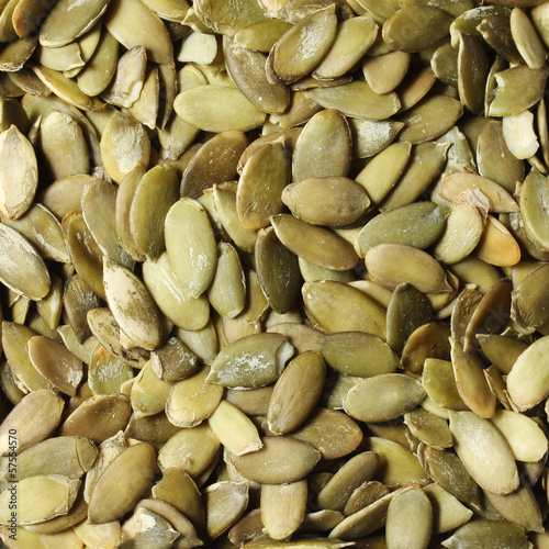Pumpkin seeds background. Peeled and green