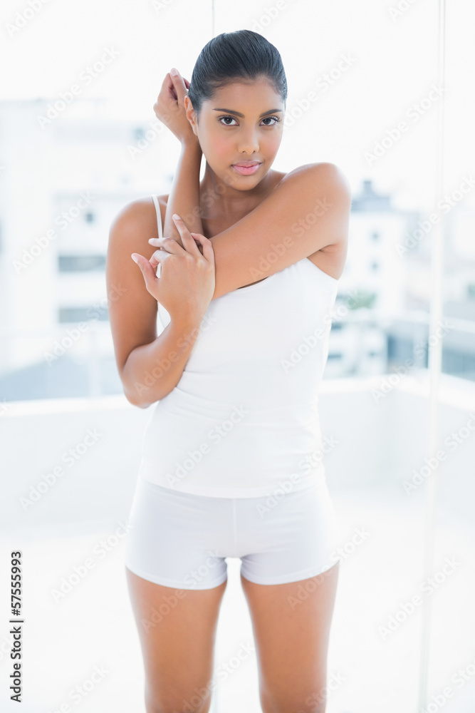 Unsmiling toned brunette posing and looking at camera