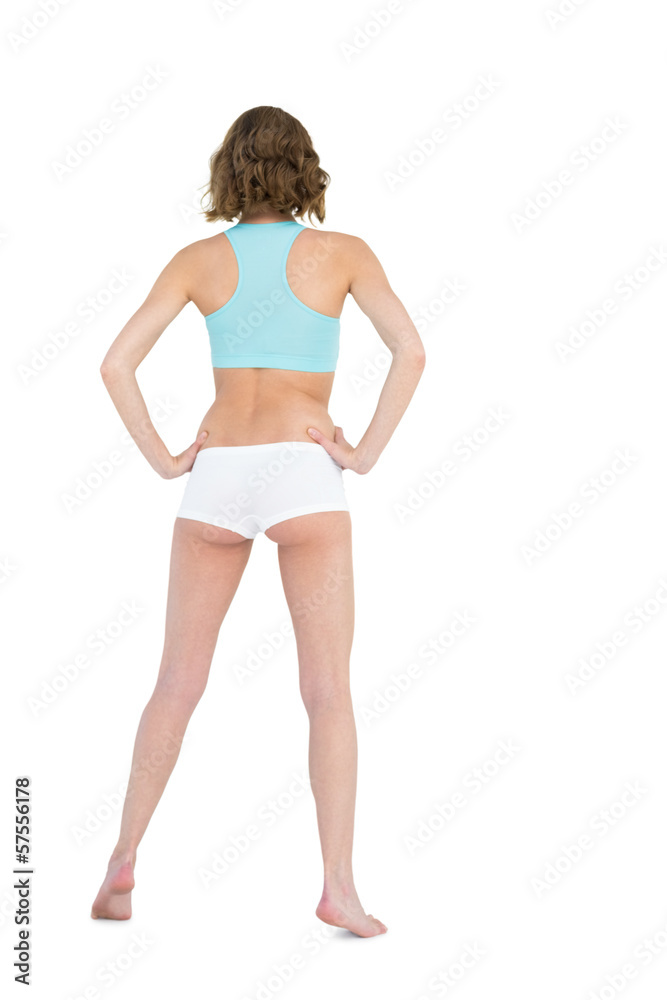 Rear view of slender young woman wearing sportswear posing with Rear view of slender young woman wearing sportswear posing with