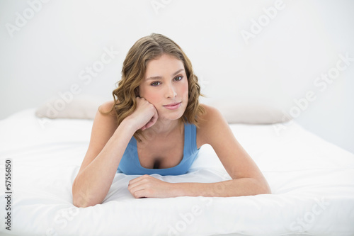 Relaxing calm woman lying on her bed leaning her head on her han