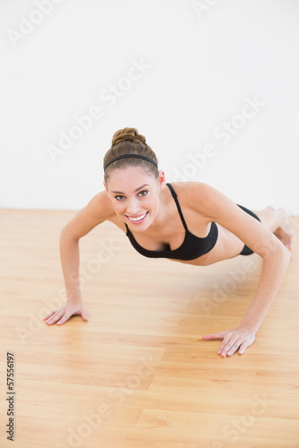 Lovely smiling woman wearing sportswear doing press ups