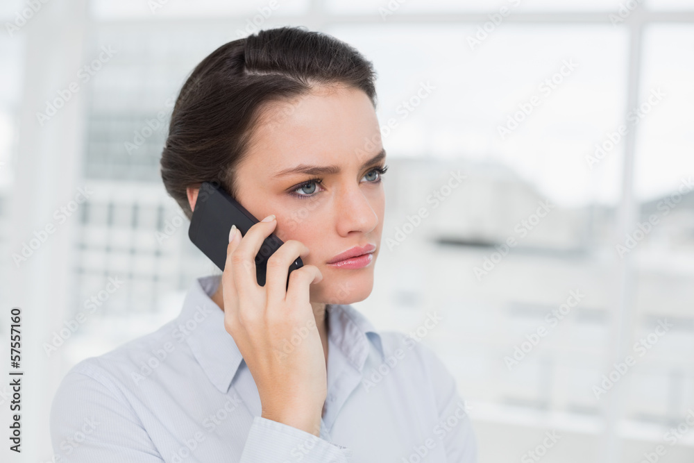 Close-up of a serious elegant businesswoman using cellphone