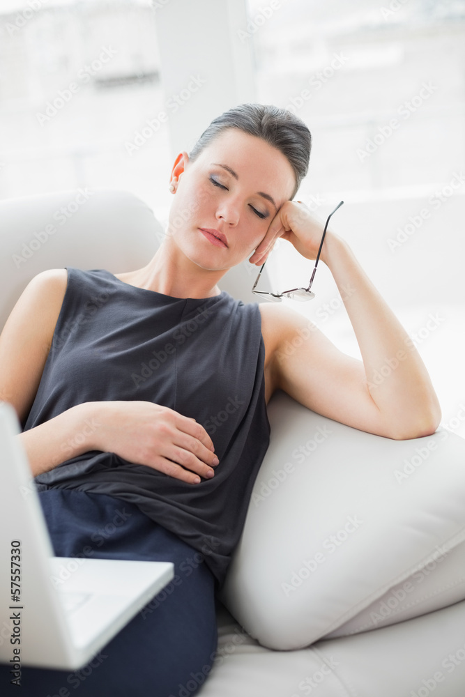 Beautiful well dressed woman resting on sofa while using laptop Beautiful well dressed woman resting on sofa while using laptop