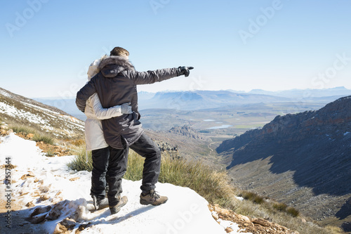Couple in jackets looking at mountain range
