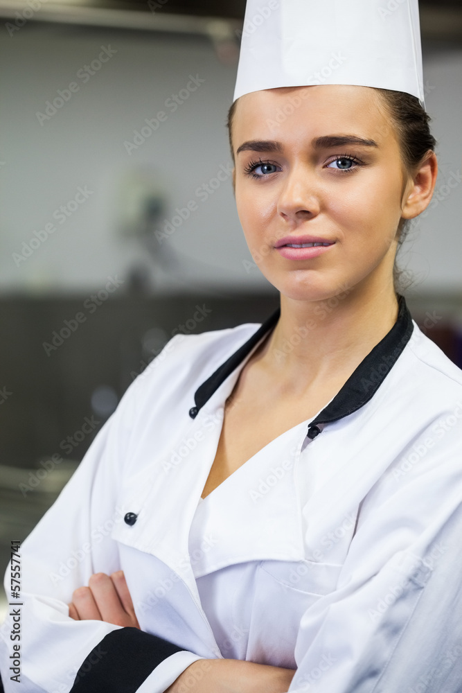 Young content chef standing arms crossed in front of hotplate Young content chef standing arms crossed in front of hotplate