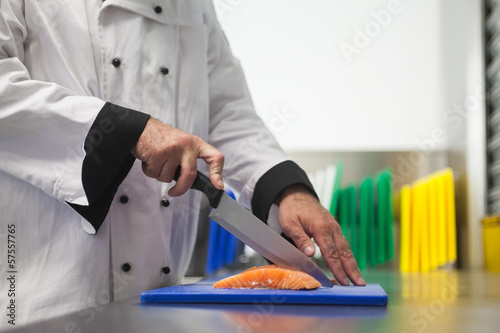 Chef cutting salmon with sharp knife
