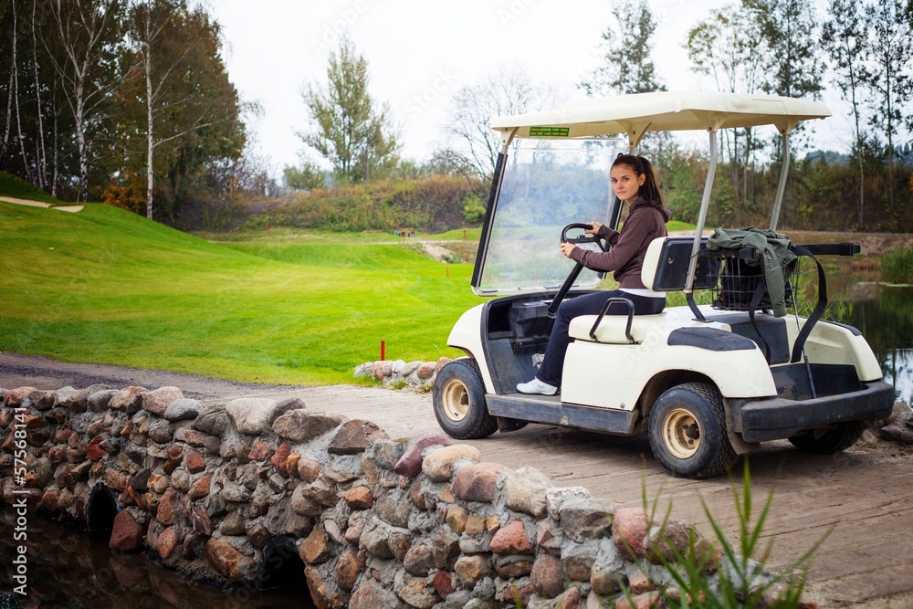 Young woman driving golf cart
