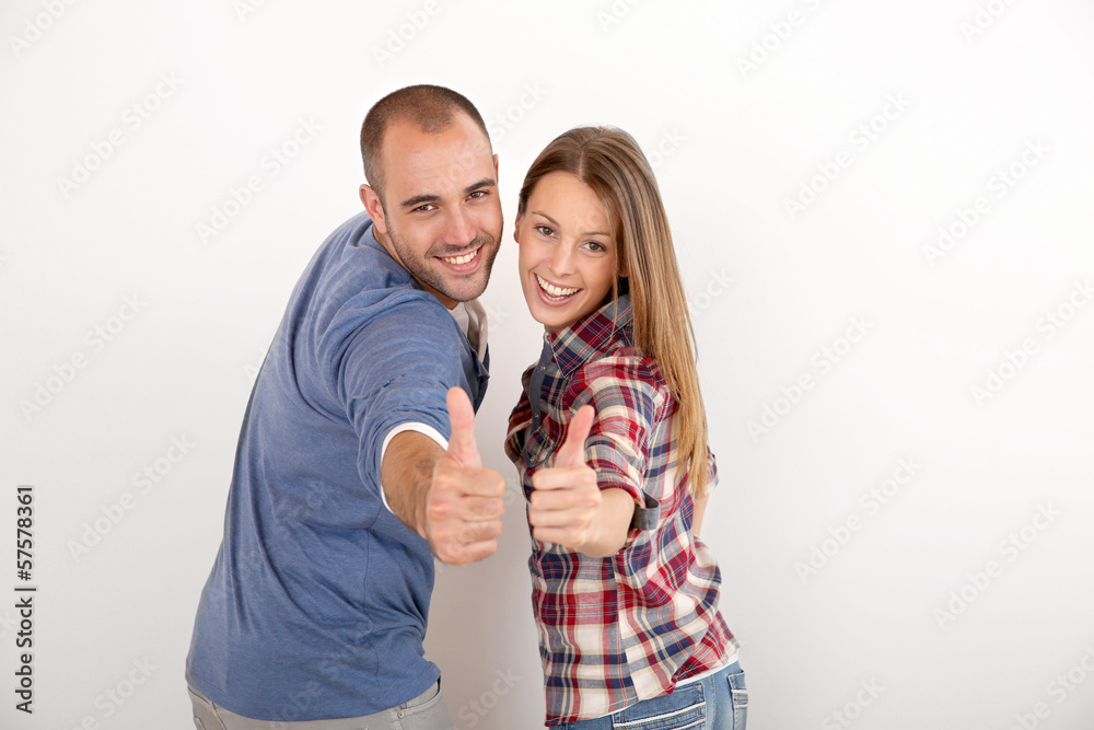 Cheerful couple showing thumbs up Cheerful couple showing thumbs up