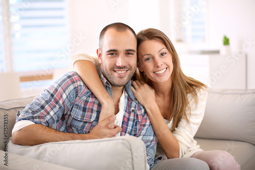 Sweet couple sitting in sofa at home