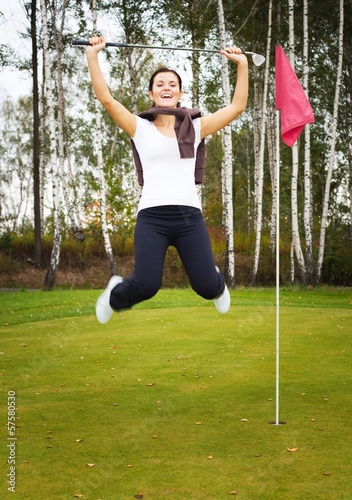 Overjoyed and smiling woman golf player in winner pose