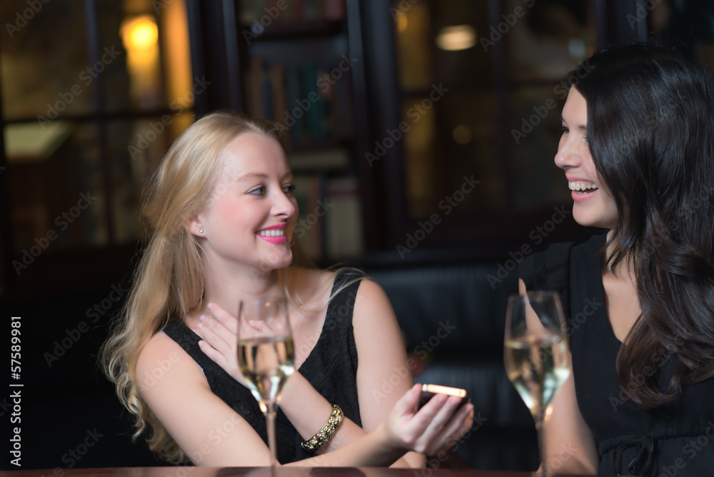 Two women on a night out using mobile phones